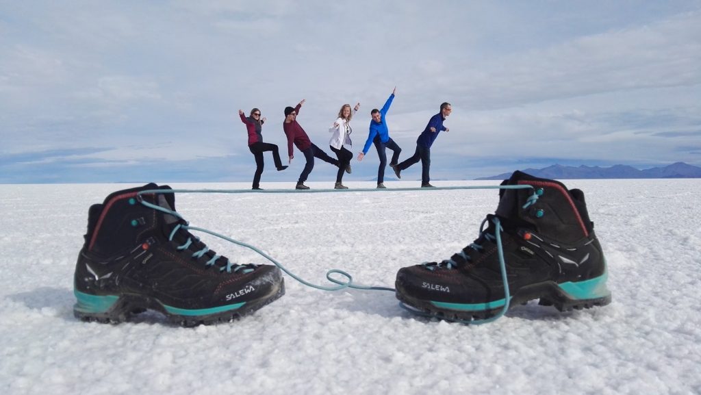 Emberek egy cipőfűzőn egyensúlyoznak a Salay de Uyuni sómezőn
