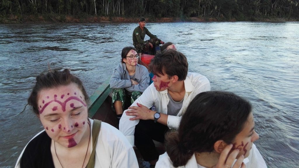 Turisták egy csónakban indián arcfestéssel