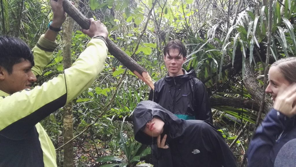Emberek liánból csorgó vízzel oltják szomjukat a dzsungelben