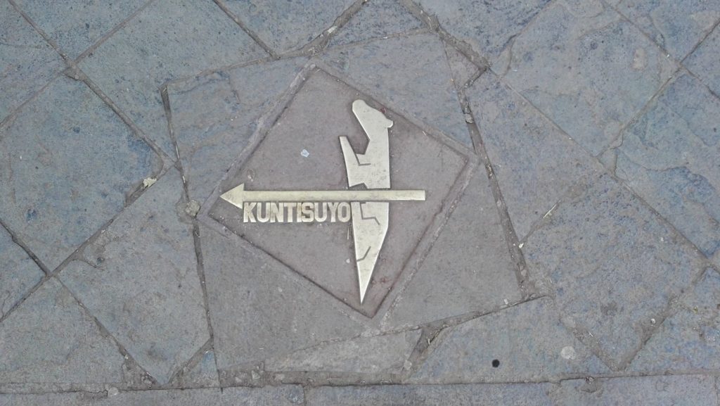 Kuntisuyo tartomány irányát mutató nyíl Cusco járdáján